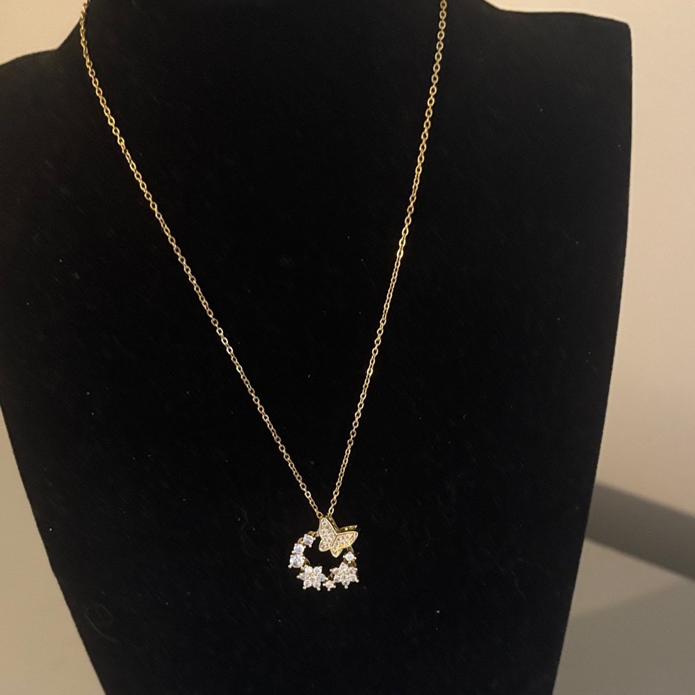Gold stainless steel delicate necklace with a butterfly and stars.
